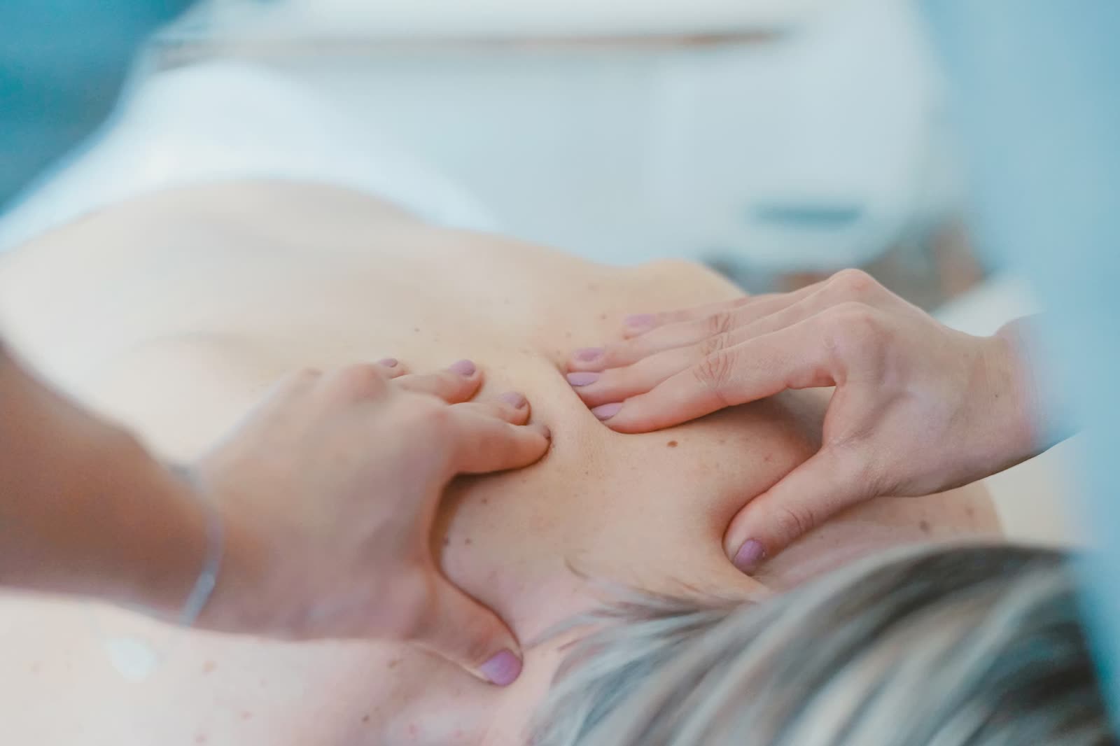 Therapist performing a back massage on a client at a Cheltenham massage studio, close up