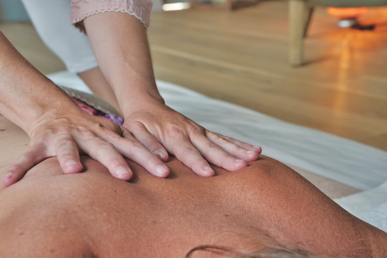 Therapist performing a back massage on a client at a Cheltenham massage studio, treatment in progress